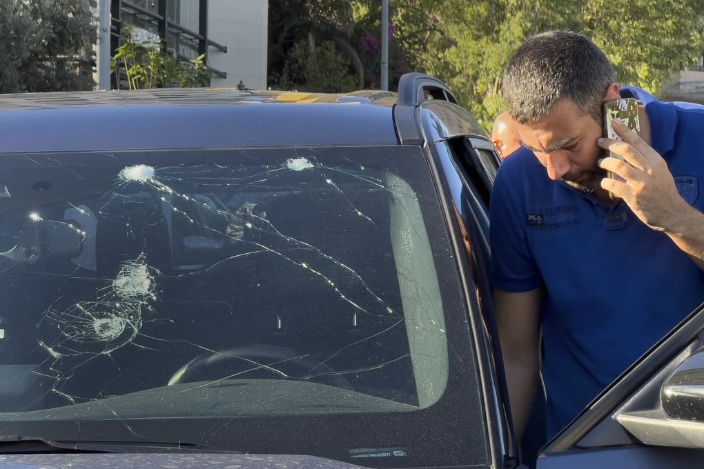 A police officer looks at a car in which a hand-held pager exploded in Beirut on Tuesday. Photo: AP