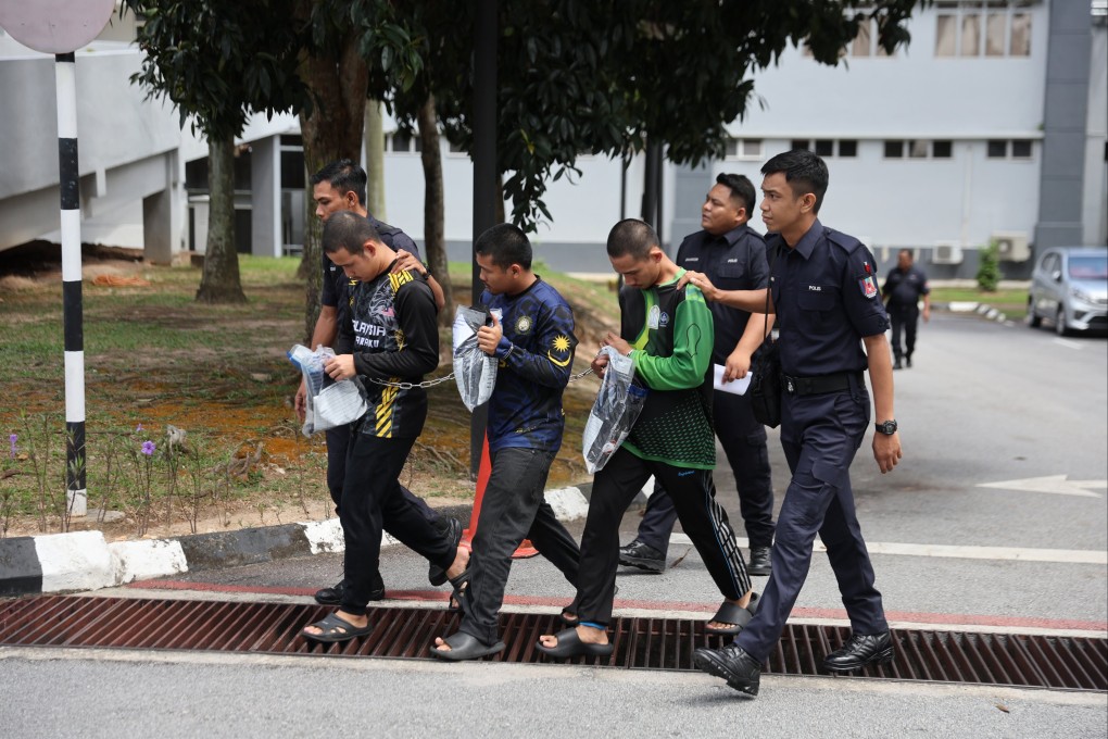 Three members of GISBH escorted by Malaysian police officers depart after facing charges at a court in Seremban on September 19. Photo: EPA-EFE
