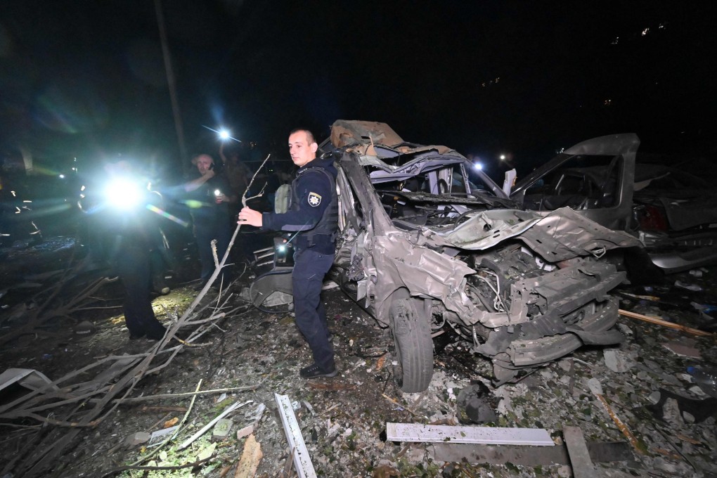 A Ukrainian police officer stands next to a car destroyed by a Russian a missile attack in Kharkiv late on September 21, 2024. Photo: AFP