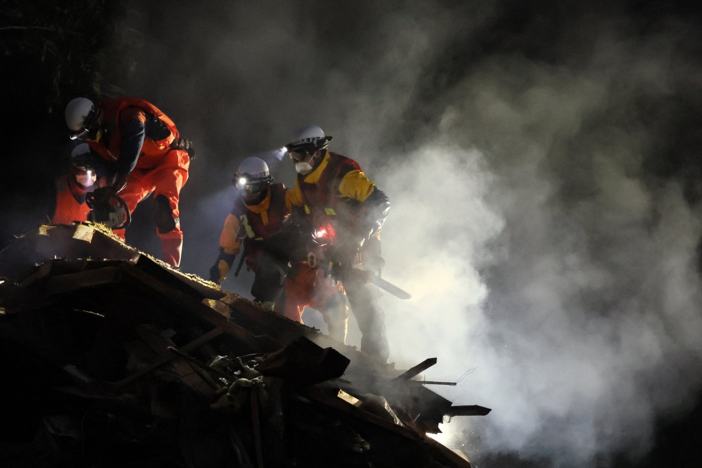 Firefighters in Wajima city search for missing people on Sunday night after torrential rain and heavy floods. Photo: Jiji Press/EPA-EFE