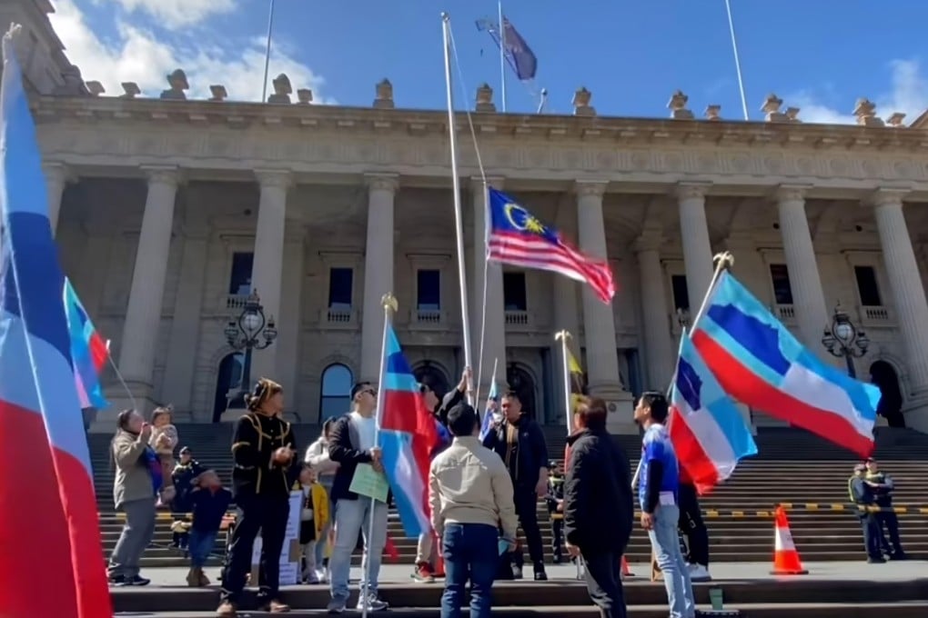 A still from the viral video shows the Malaysian national flag being lowered down a makeshift flagpole outside Parliament House in Melbourne, Australia. Photo: Facebook/MossesPA
