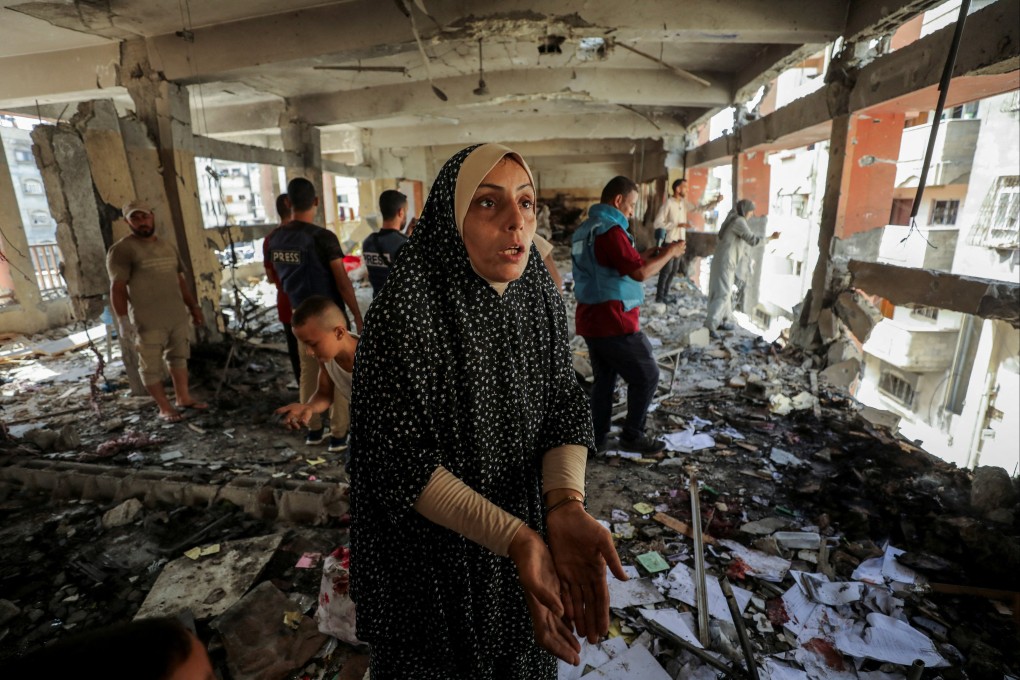 A Palestinian woman inspects the damage to a school sheltering displaced people after it was hit by an Israeli strike at Beach refugee camp in Gaza City on Monday. Photo: Reuters