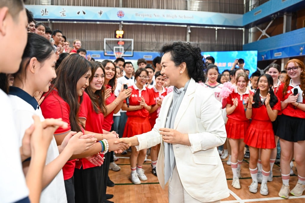Peng Liyuan, wife of Chinese President Xi Jinping, shakes hands with students at Beijing No. 8 High School during a sports and culture event on Tuesday. Photo: Xinhua