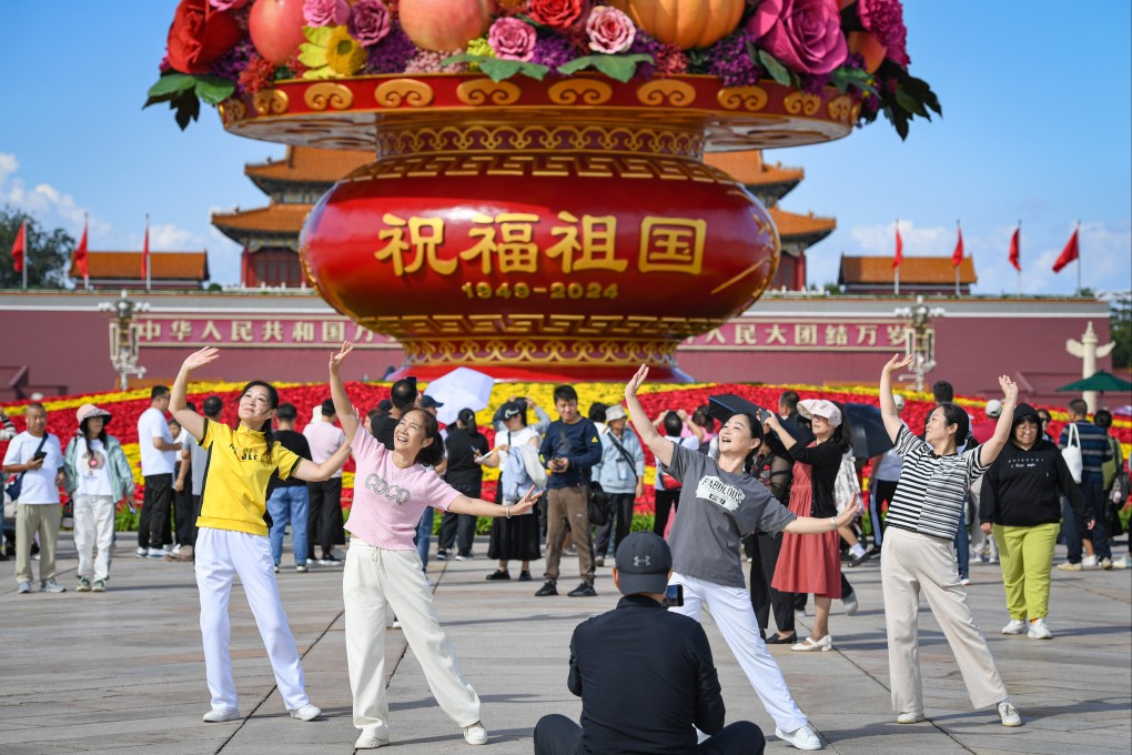 People pose for photo with a flower basket at Tiananmen Square in Beijing. Photo: Xinhua