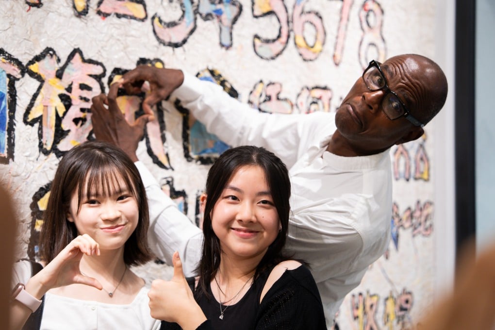 Mark Bradford poses with students in front of a mural in Sham Shui Po created as part of gallery Hauser & Wirth’s Education Lab in Hong Kong. The American artist’s exhibition at the gallery runs until March 1, 2025. Photo: Ivan Chan