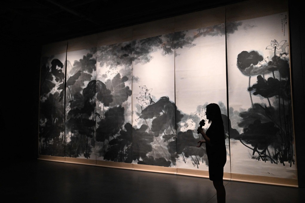 A Sotheby’s art expert speaks in front of Chinese artist Chang Dai-chien’s masterpiece “The Giant Lotuses” in Hong Kong on September 13. At over 3 metres tall and 8 metres wide, it is the largest known work created by the artist. This was the first time it had been seen in Asia. Photo: AFP