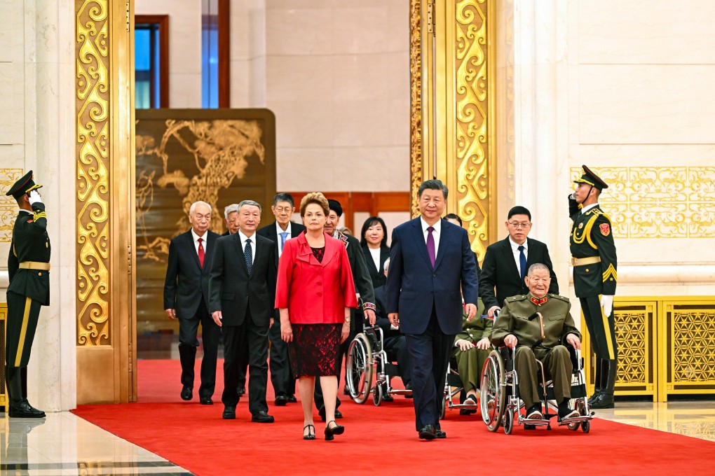 President Xi Jinping arrives for the awards ceremony alongside recipients including former Brazilian president Dilma Rousseff and war hero Huang Zongde (in wheelchair), at the Great Hall of the People in Beijing on Sunday. Photo: Xinhua