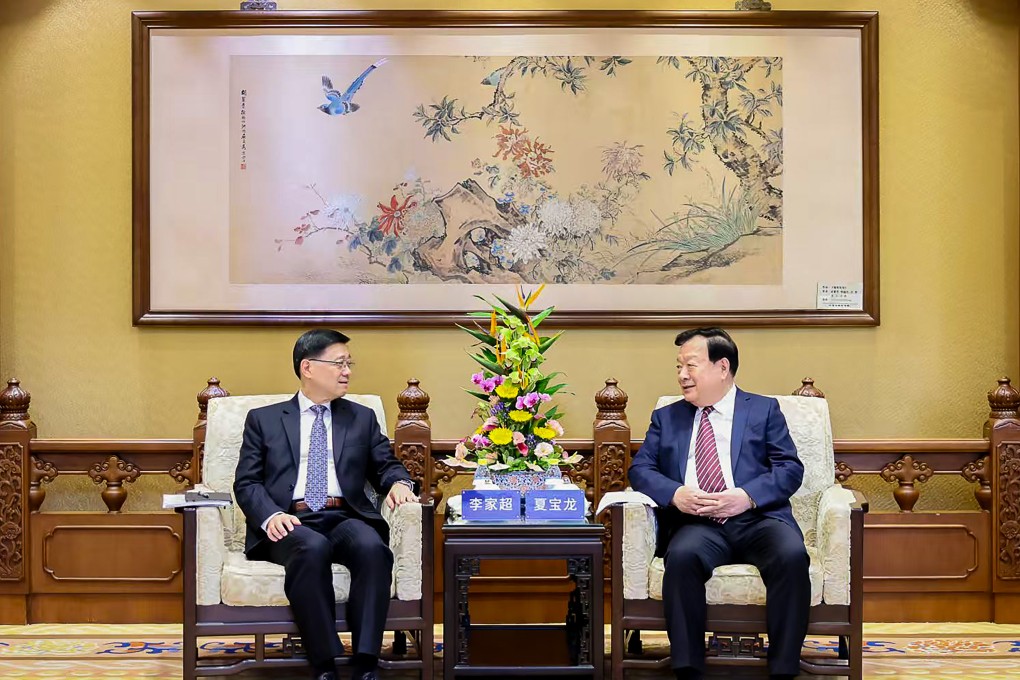 Hong Kong Chief Executive John Lee Ka-chiu, left, with Hong Kong and Macau Affairs Office director Xia Baolong in Beijing recently.    Photo: Hong Kong and Macau Affairs Office