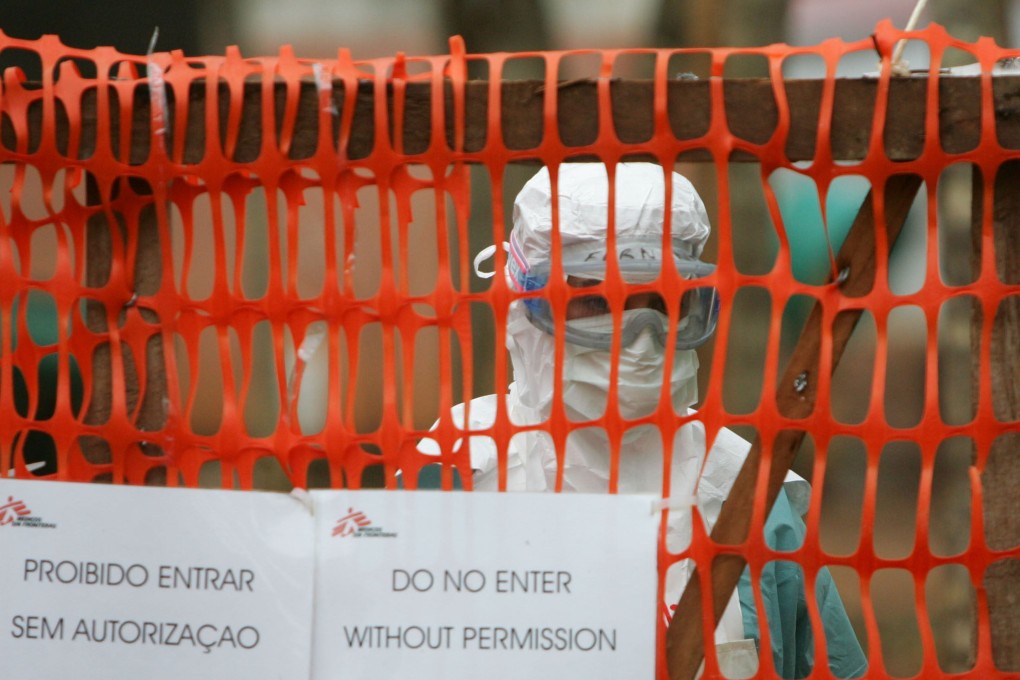 A health worker in protective clothing peers out from behind barriers marking an isolation ward for victims of the deadly Marburg virus. File photo: Reuters