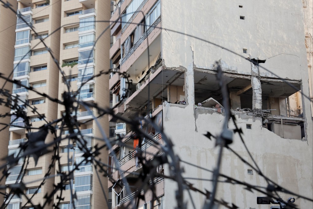 A building damaged in an Israeli strike, as seen through a razor wire fence, in Kola, central Beirut, Lebanon. Photo: Reuters