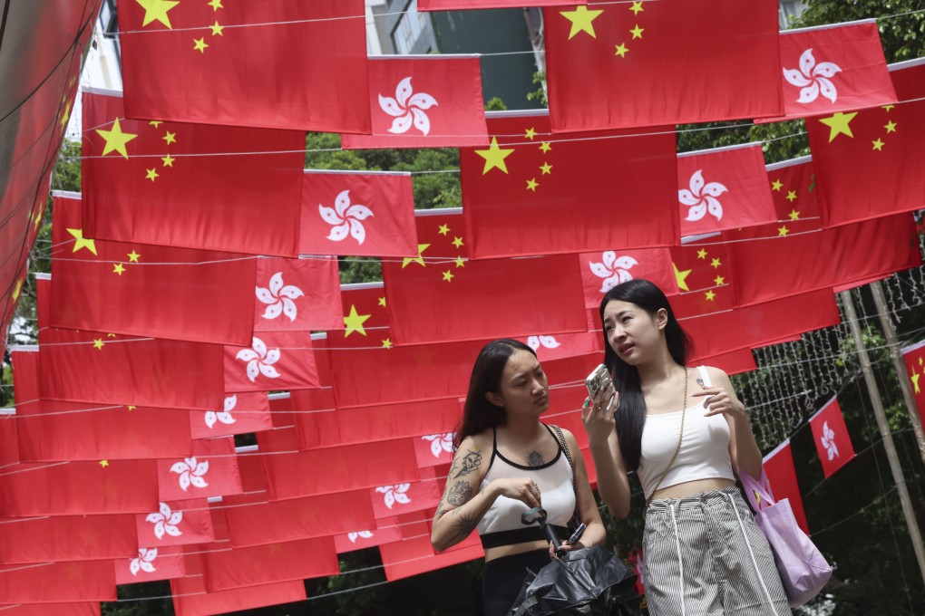 On September 25, 2024, tourists walk along Park Lane Shopper’s Boulevard in Tsim Sha Tsui, which is festooned with flags to celebrate the 75th anniversary of the founding of the People’s Republic of China. Photo: Jelly Tse