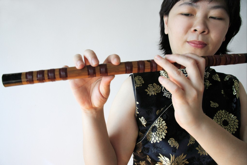 A woman plays a dizi, a Chinese bamboo flute. The first flutes excavated in China were made from bone. Today, ones made from bamboo are widely used in Chinese music and opera. Photo: Getty Images