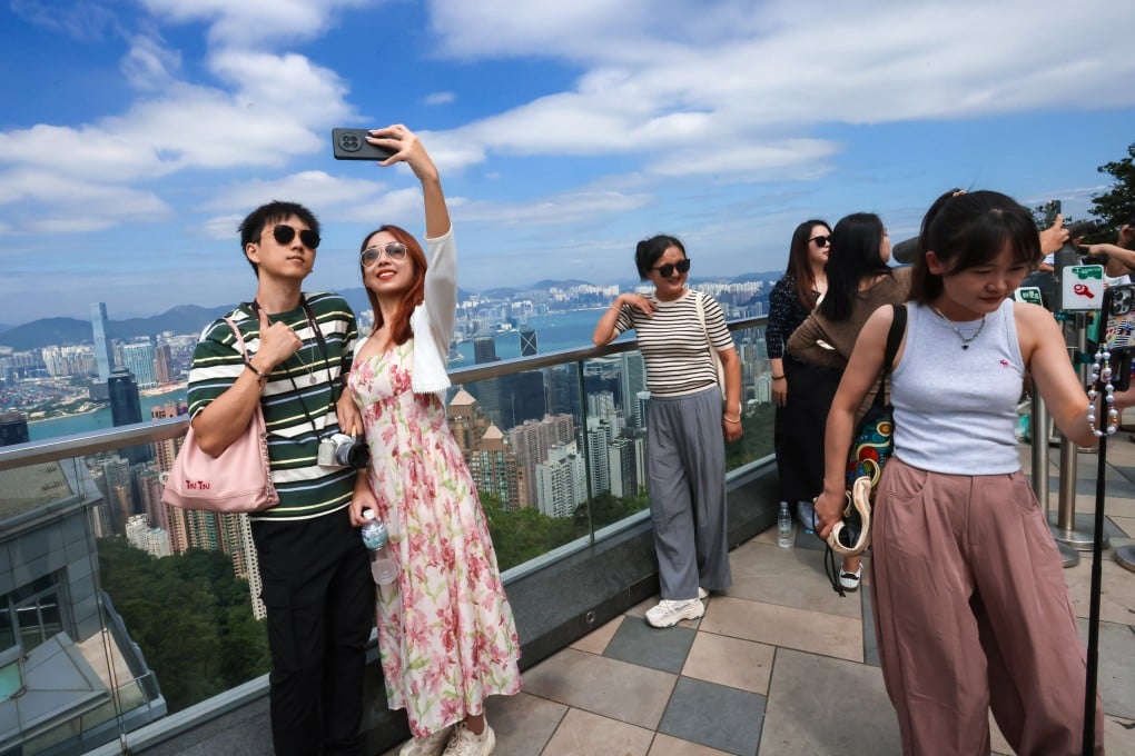 Visitors pose for photos against the backdrop of Hong Kong’s iconic skyline. Photo: Jonathan Wong