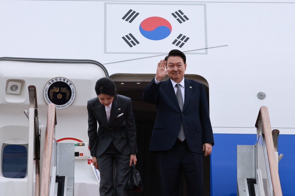 South Korean President Yoon Suk-yeol waves as first lady Kim Keon-hee bows next to him before their departure to the Philippines on the first leg of a three-nation tour.  Photo: EPA-EFE/Yonhap