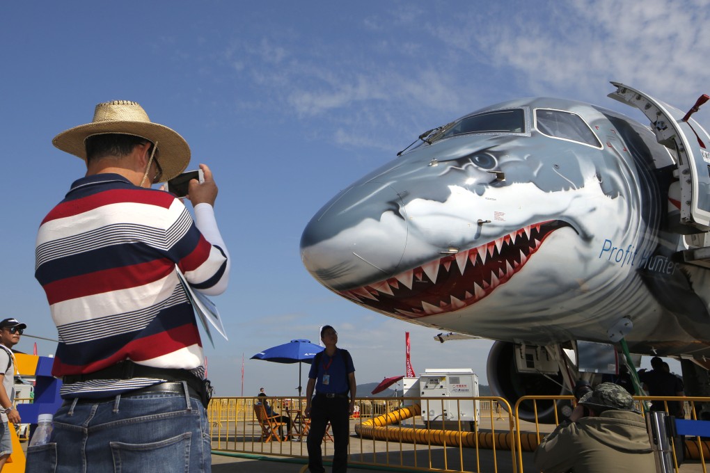 A man takes photo of an Embraer E190-E2 during the 12th China International Aviation and Aerospace Exhibition in Zhuhai in 2018. Photo: AP