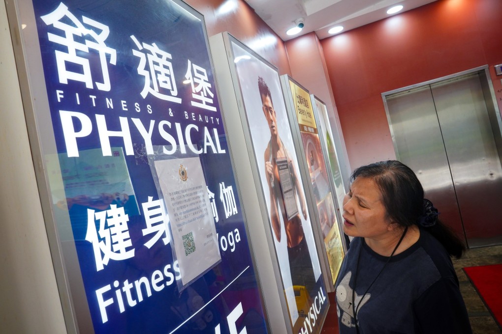 A woman reads a notice from customs in September saying the department is investigating the gym chain Physical. Photo: Elson Li