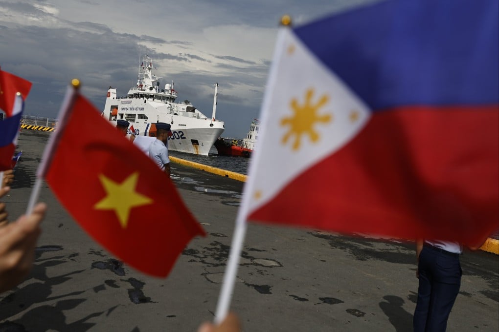Philippine Coast Guard personnel wave flags as the Vietnam Coast Guard CSB-8002 patrol ship makes a port call at the Port of Manila. Photo: EPA-EFE