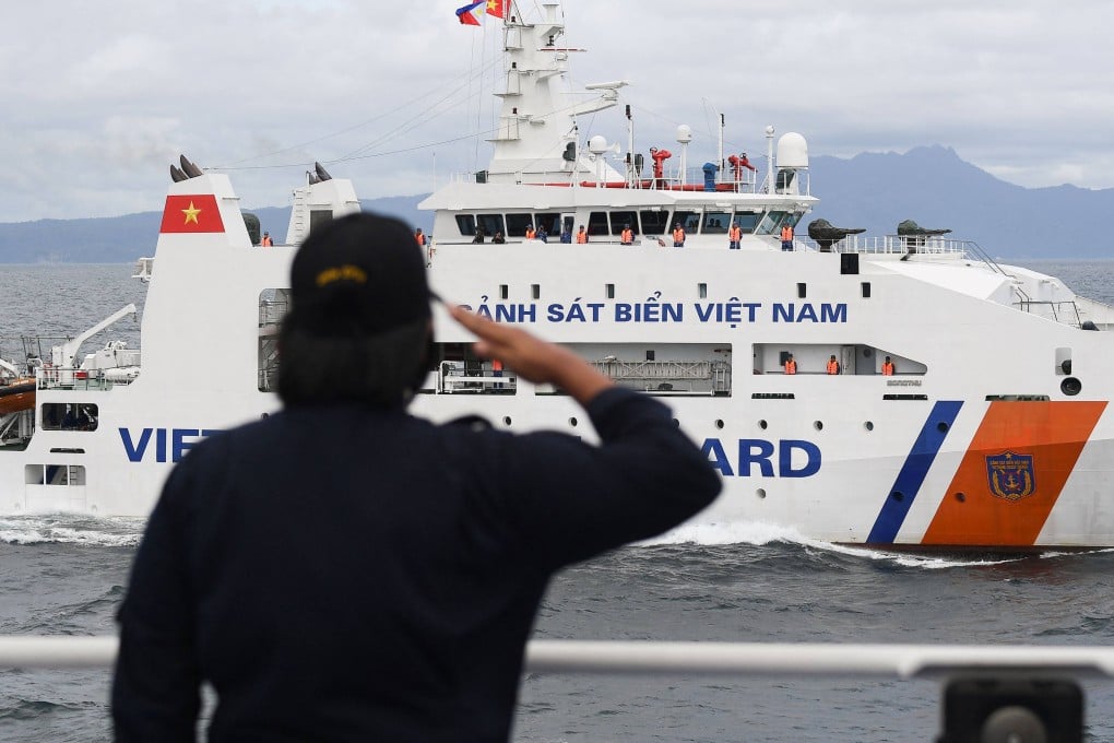 A member of the Philippine Coast Guard personnel salutes as a Vietnamese Coastguard ship during a joint maritime exercise in the disputed South China Sea on August 9. Photo: AFP