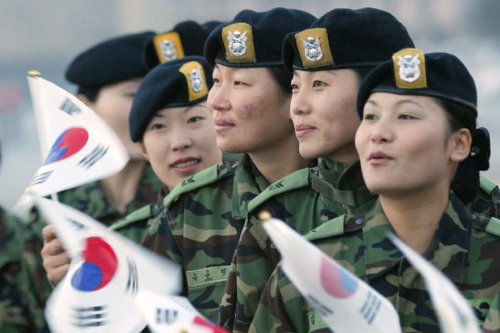 South Korean soldiers wave national flags to say goodbye as their colleagues depart for Iraq at Seoul military airport on October 22, 2003. Photo: Reuters