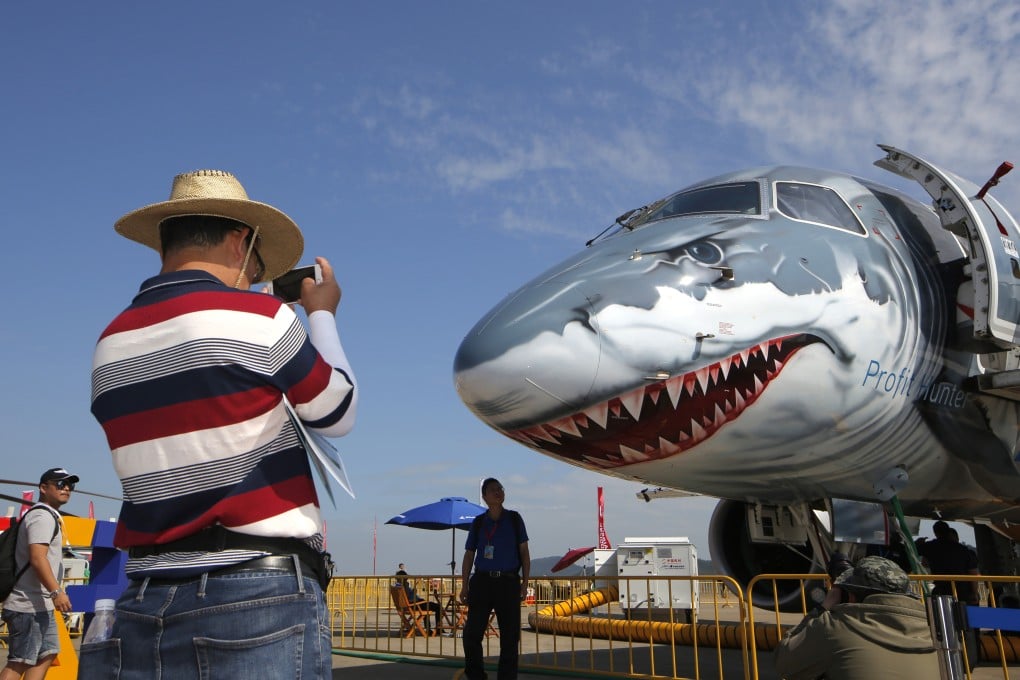 A man takes a photo of an Embraer E190-E2 during the China International Aviation and Aerospace Exhibition in Zhuhai in 2018. Photo: AP