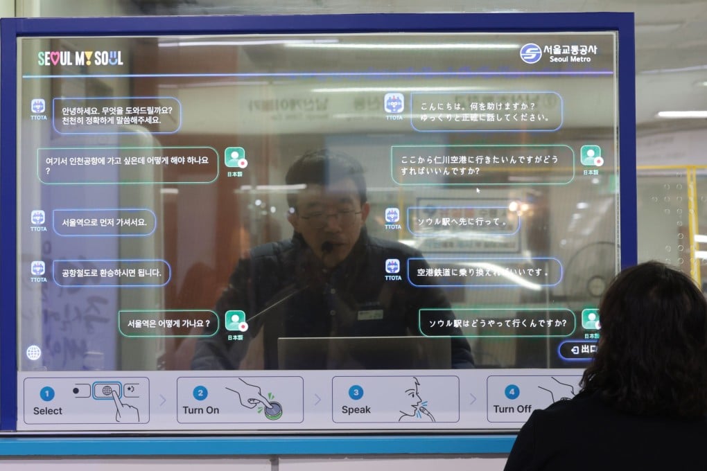 A station employee converses simultaneously with a foreigner in their respective mother tongues through a transparent OLED screen at a subway station in Seoul, South Korea. Photo: EPA-EFE/Yonhap