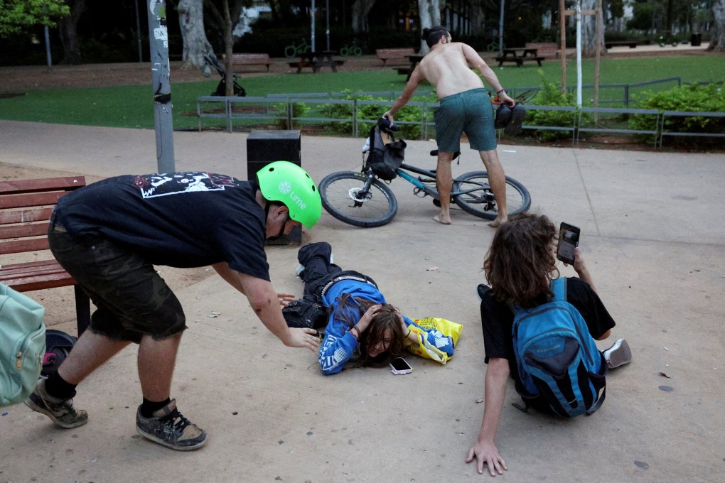 People take cover in Tel Aviv, Israel as sirens sound in response to projectiles fired from Lebanon. Photo: Reuters