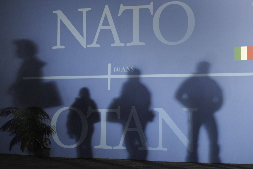 Nato summit attendees’ shadows cast on a wall decorated with the Nato logo and flags. Photo: AFP