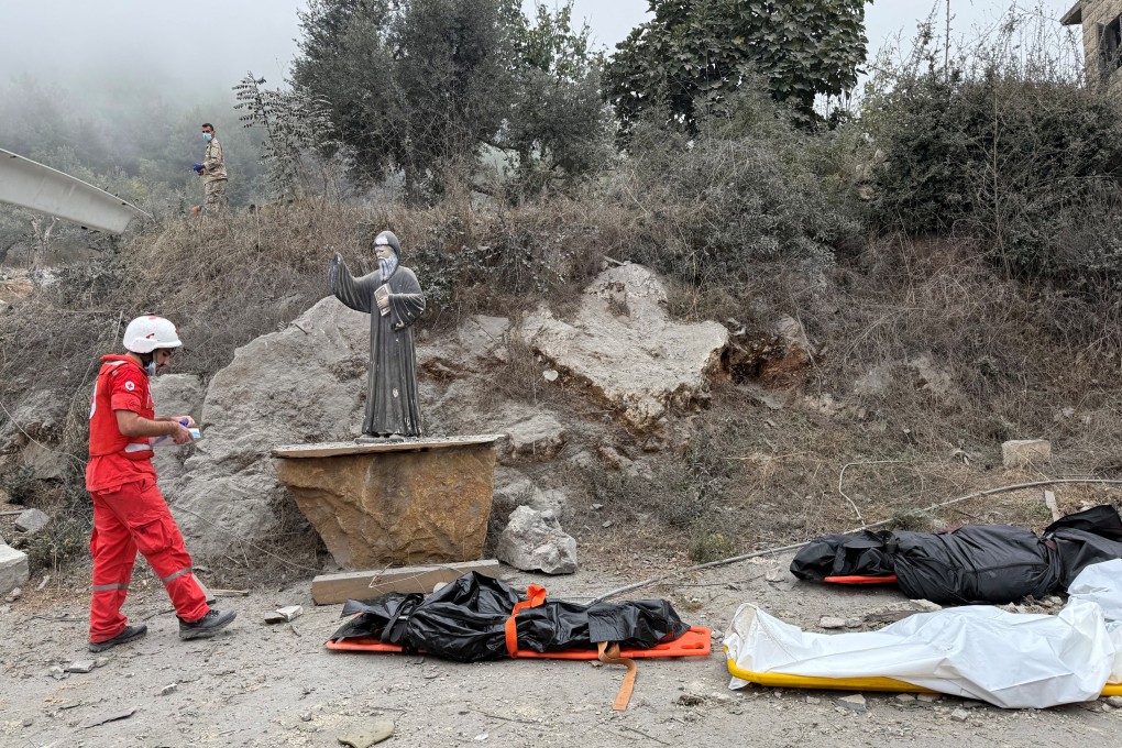 A member of the Lebanese Red Cross stands near casualties in bodybags at a site damaged by an Israeli strike in the Christian-majority region of Aitou in north Lebanon on Monday. Photo: Reuters