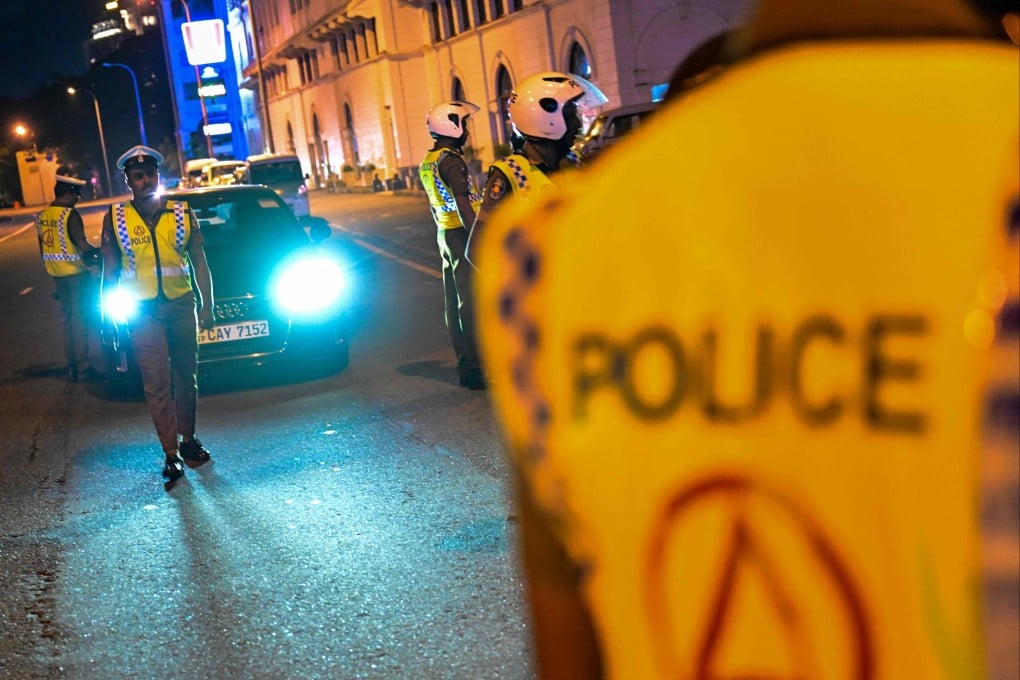 Police officers stand guard at a checkpoint in Colombo. The biggest raid was on Saturday, when police arrested 126 Chinese men. Photo: AFP