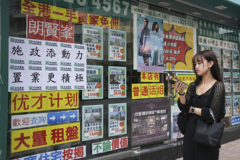A slogan encouraging property purchases based on the latest policy address is posted at a real estate agency in Mong Kok. Photo: Elson Li