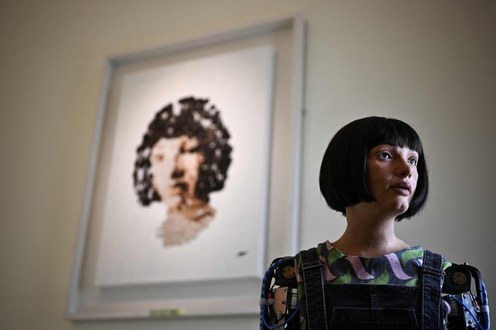 Ai-Da poses in front of a painting she made during the press preview of the London Design Biennale 2023 at Somerset House, central London, in June 2023. Photo: AFP