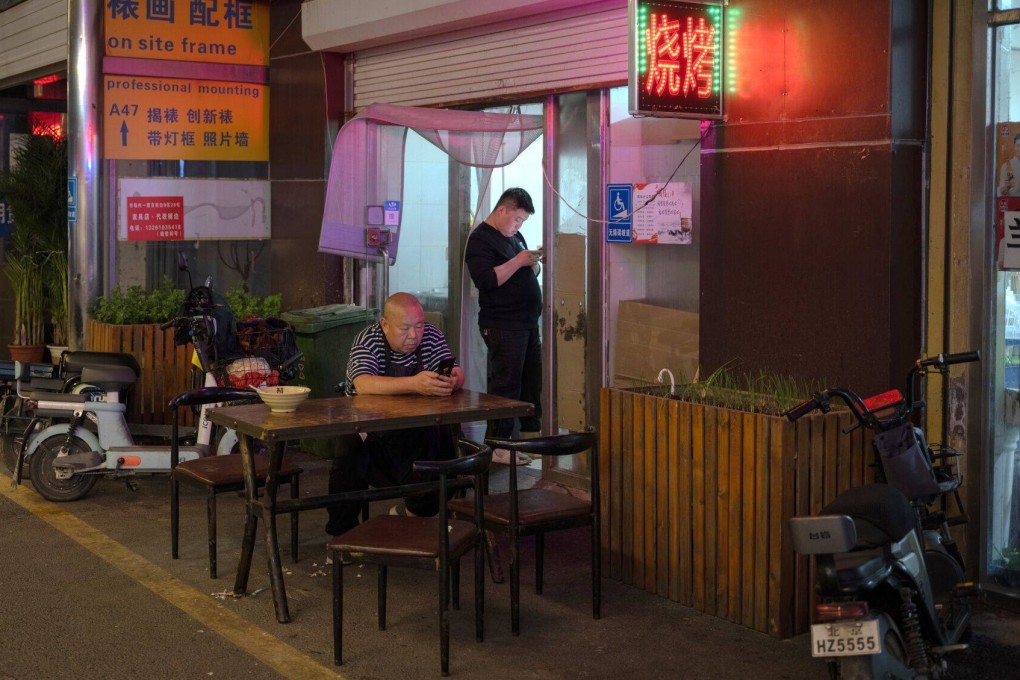 A customer sits outside a restaurant in Beijing on October 11. Financial markets have no stomach for delay and conflicting policy signals. Photo: Bloomberg