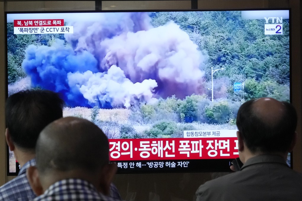 People at Seoul Railway Station in South Korea watch a television broadcast of North Korea blowing up parts of inter-Korean roads on October 15. Photo: AP