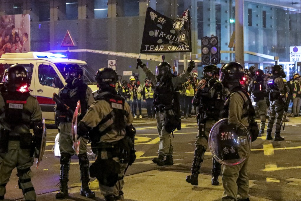 Police hold up a banner to warn demonstrators before firing tear gas in 2019. Photo: May Tse