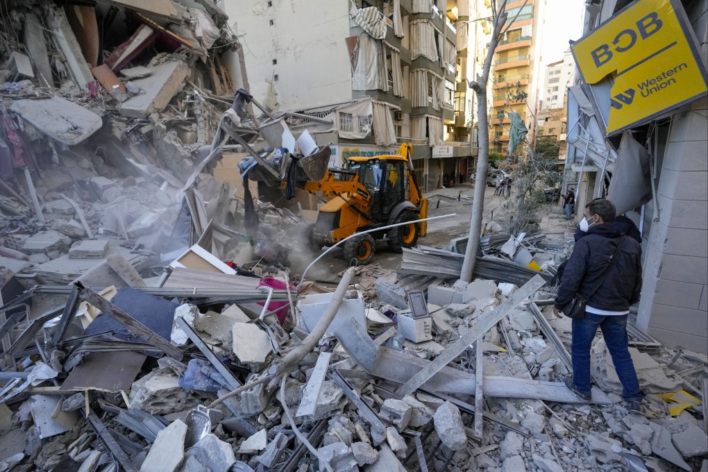 Rescue workers use a bulldozer to remove rubble of destroyed buildings at the site of an Israeli airstrike that hit several branches of the Hezbollah-run al-Qard al-Hassan in Beirut’s southern suburb. Photo: AP