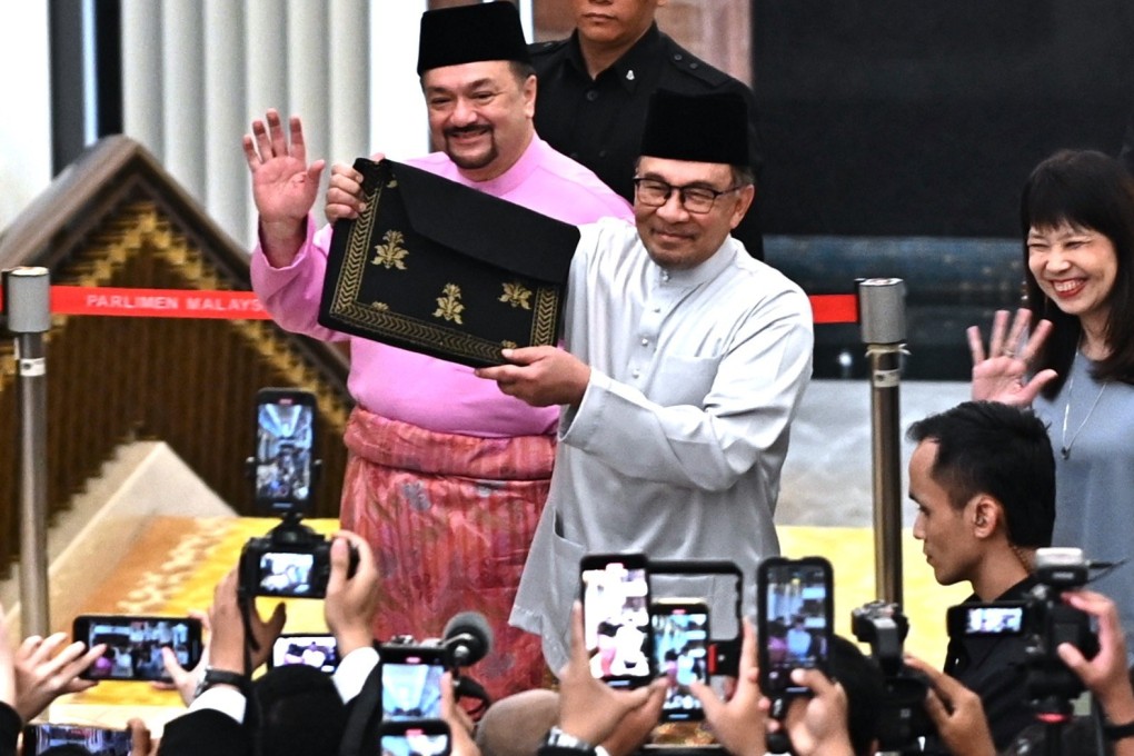 Malaysian Prime Minister Anwar Ibrahim holds up a briefcase containing his 2025 budget speech at parliament on Friday. Photo: Malaysia’s Department of Information/EPA-EFE