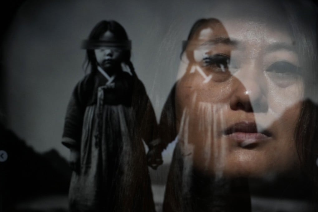 South Korean adoptee Rebecca Kimmel, 49, is seen reflected in her artwork depicting twins at her home in Seattle, US, on February 3, 2024. Kimmel believes her adoption agency switched her identity with another girl, and that she may have a twin. Photo: AP