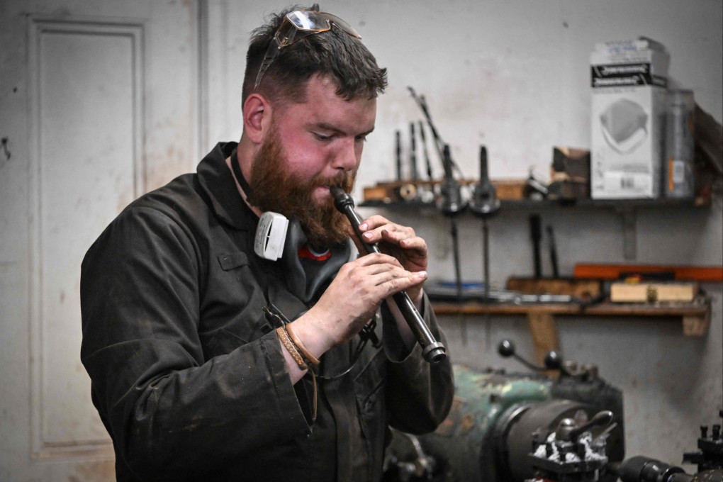 Artisan bagpipe maker Ruari Black, one of the last traditional bagpipe-makers in Scotland to make everything by hand, tests a bagpipe chanter in the workshop of Kilberry Bagpipes in Edinburgh, Scotland. Photo: AFP