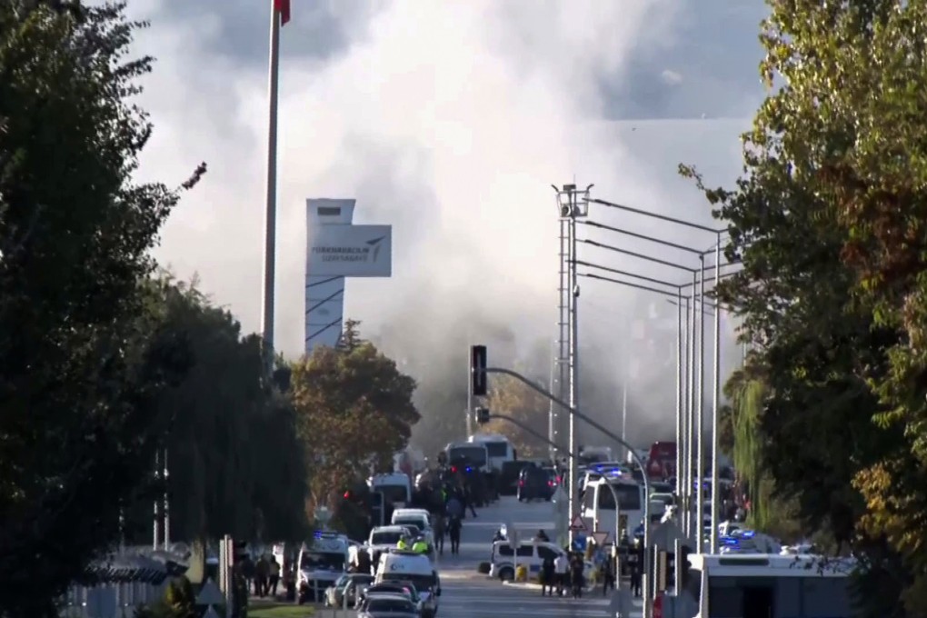 Smoke rises as emergency rescue teams and police officers show up outside Turkish Aerospace Industries on the outskirts of Ankara. Photo: AP