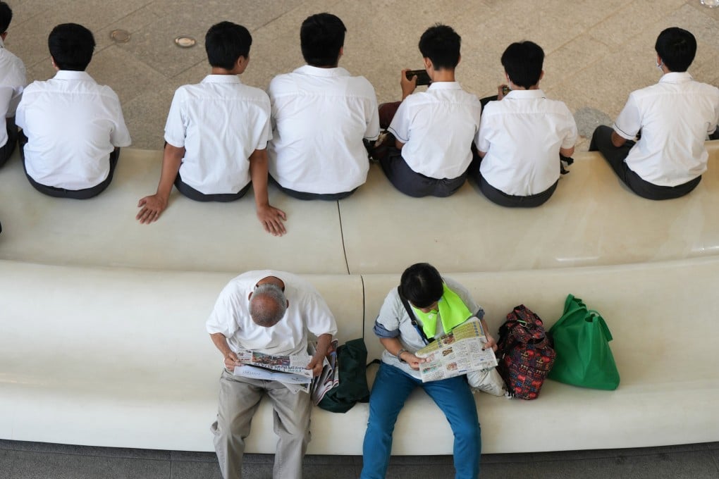 Students look at their phones while two elderly people read newspapers on a bench in Tsim Sha Tsui, Hong Kong. Photo: Eugene Lee