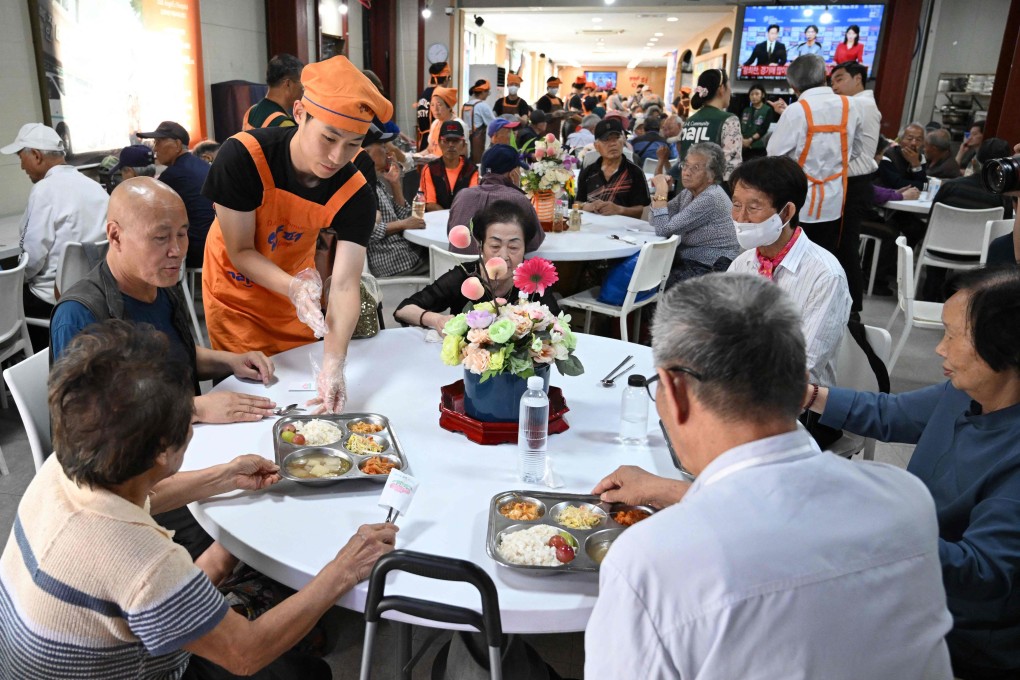 Volunteers serve free hot meals at the “Babfor” service centre in Seoul. Photo: AFP