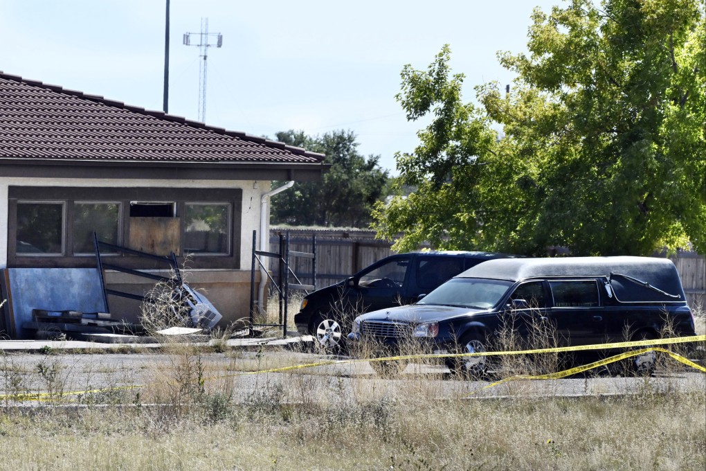 A hearse and debris at the rear of the Return to Nature Funeral Home in Penrose, Colorado in 2023. Photo: The Gazette via AP