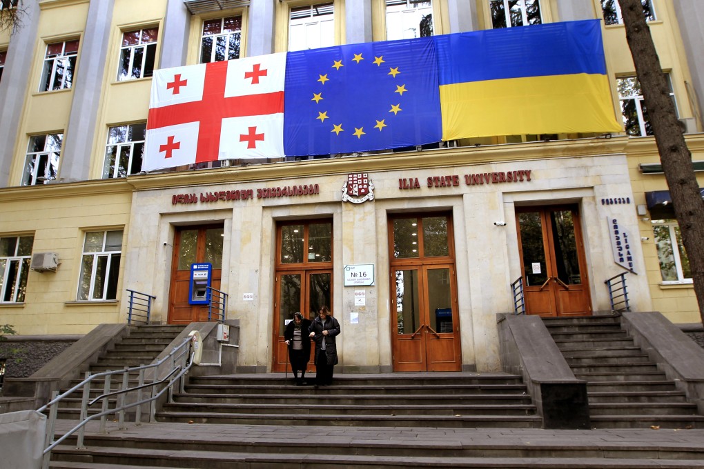 The flags of Georgia, the EU, and Ukraine hanging at a polling station during the parliamentary election in Tbilisi, Georgia, on Saturday. Photo: AP