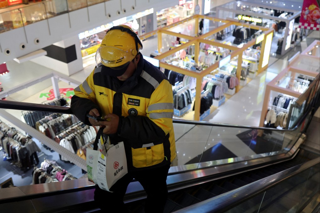 A Meituan delivery worker picks up a food order at a shopping mall in Beijing. Photo: Reuters