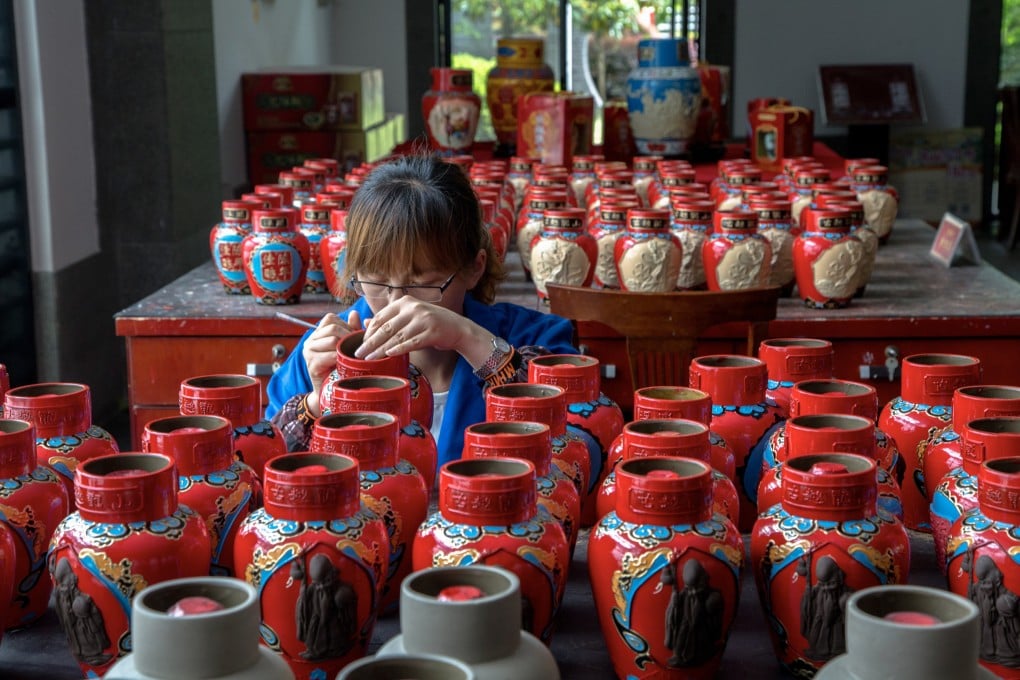 A woman paints nu’er hong containers in Shaoxing, eastern China. The vessels, adorned with auspicious motifs and colours, often feature at Chinese weddings. Photo: Getty Images