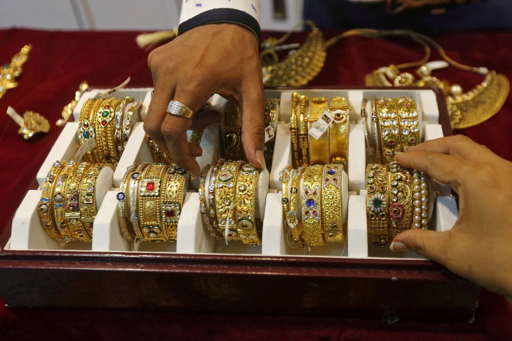 A salesman helps a customer select gold bangles at a jewellery showroom in Mumbai. Gold prices near record highs, driven by US election uncertainty, are dampening India’s peak festival gold buying season, with sales down 10-20 per cent. Photo: Reuters
