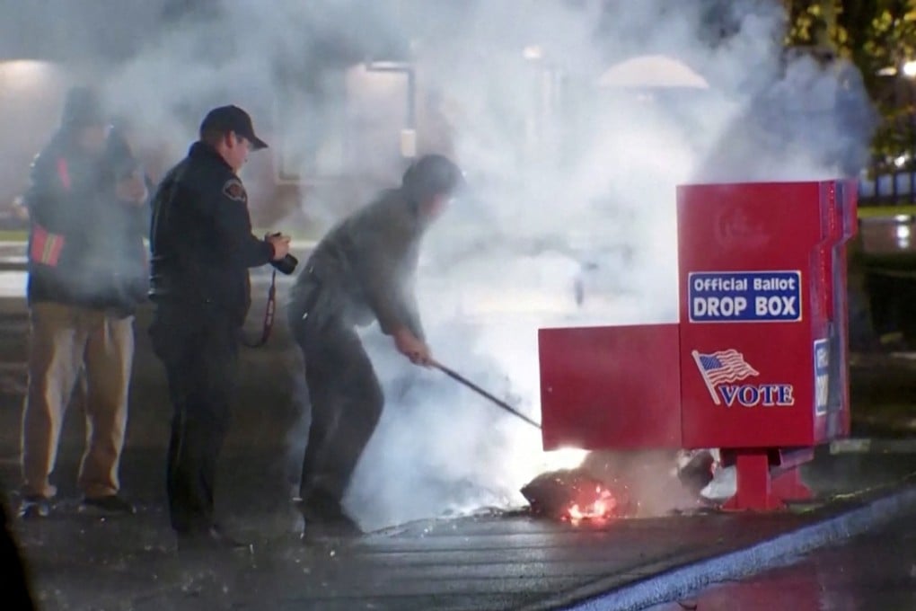 First responders pull burning contents out of a ballot box in Vancouver, Washington. Photo: Evan Bell/ABC Affiliate KATU via Reuters