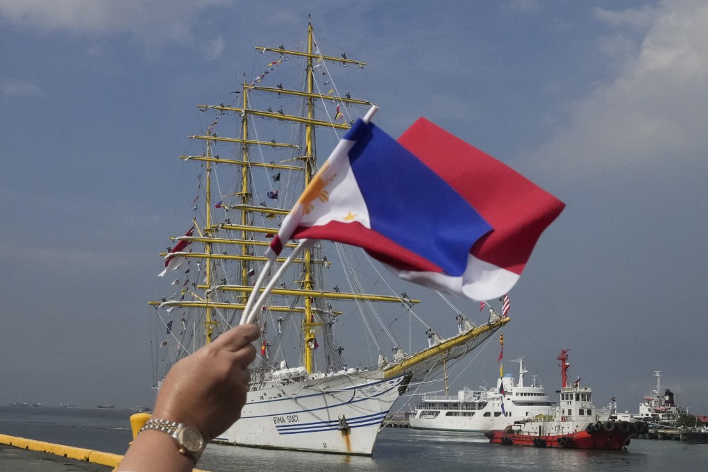 A woman waves the Philippine and Indonesian flags as an Indonesian Navy training ship prepares to dock for a goodwill visit in Manila on October 15. Photo: AP