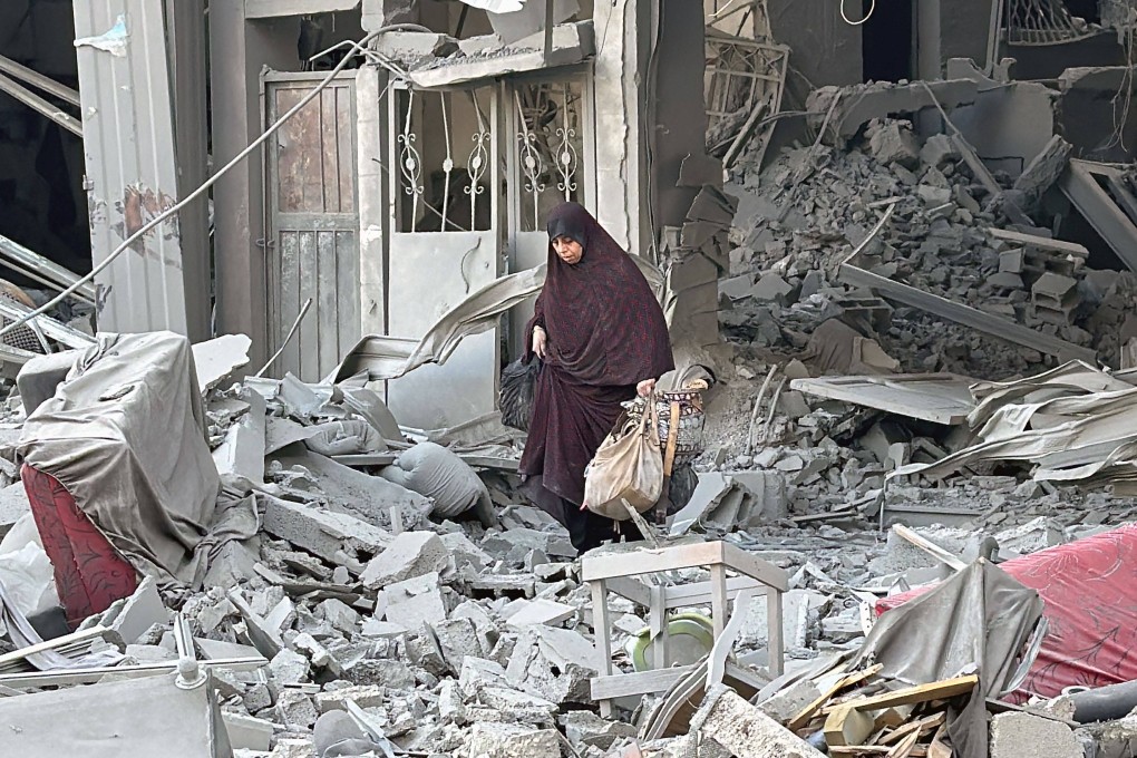 A woman walks over rubble in Beit Lahiya in the northern Gaza Strip on Monday. Photo: AFP