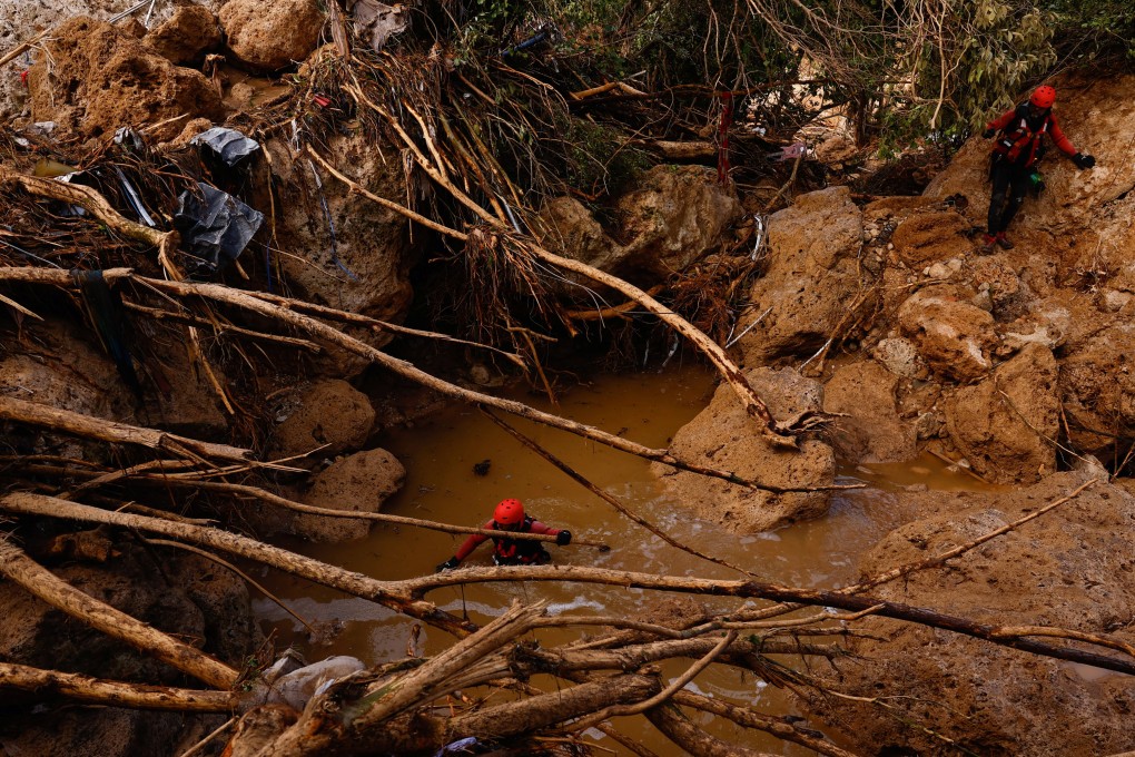 Members of a rescue team search for missing people near a river after heavy rains caused flooding in Letur, Spain. Photo: Reuters